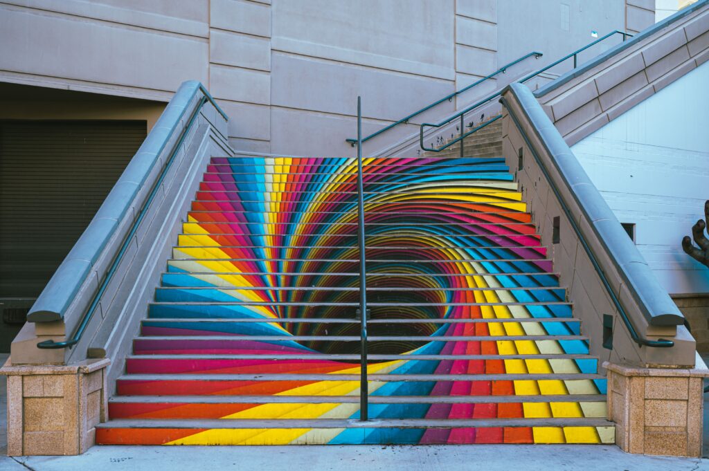 Colorful urban staircase painted with a captivating optical illusion creating a spiral effect.