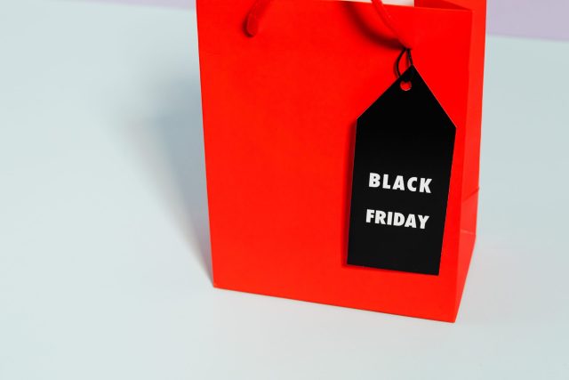 Red shopping bag with Black Friday tag, ideal for marketing promotions and discounts.